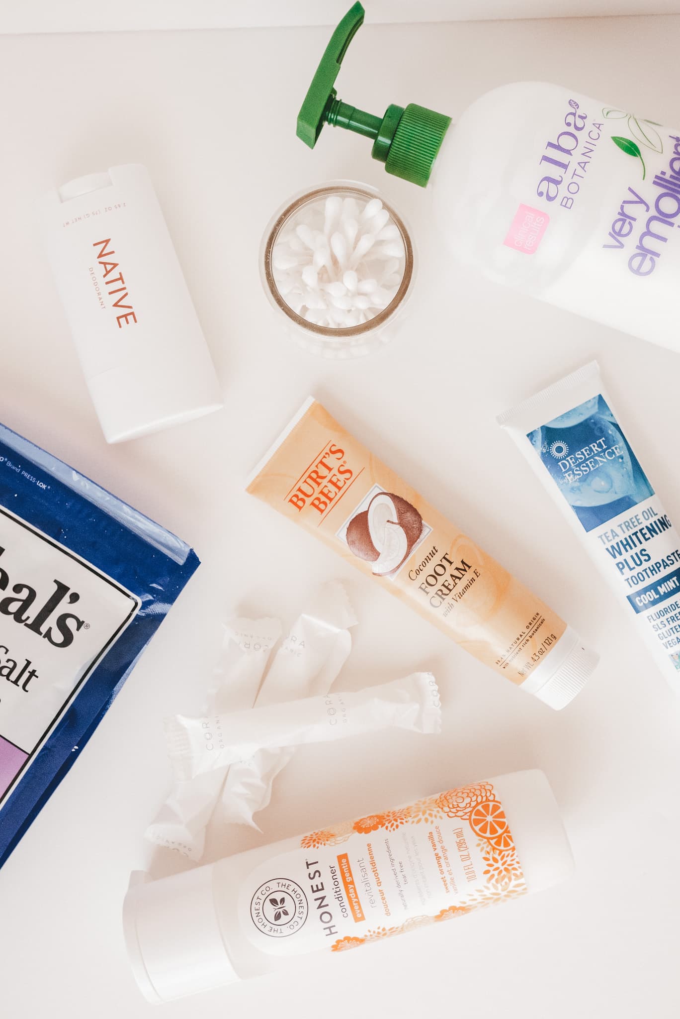 a variety of toiletry products spread out on a white background