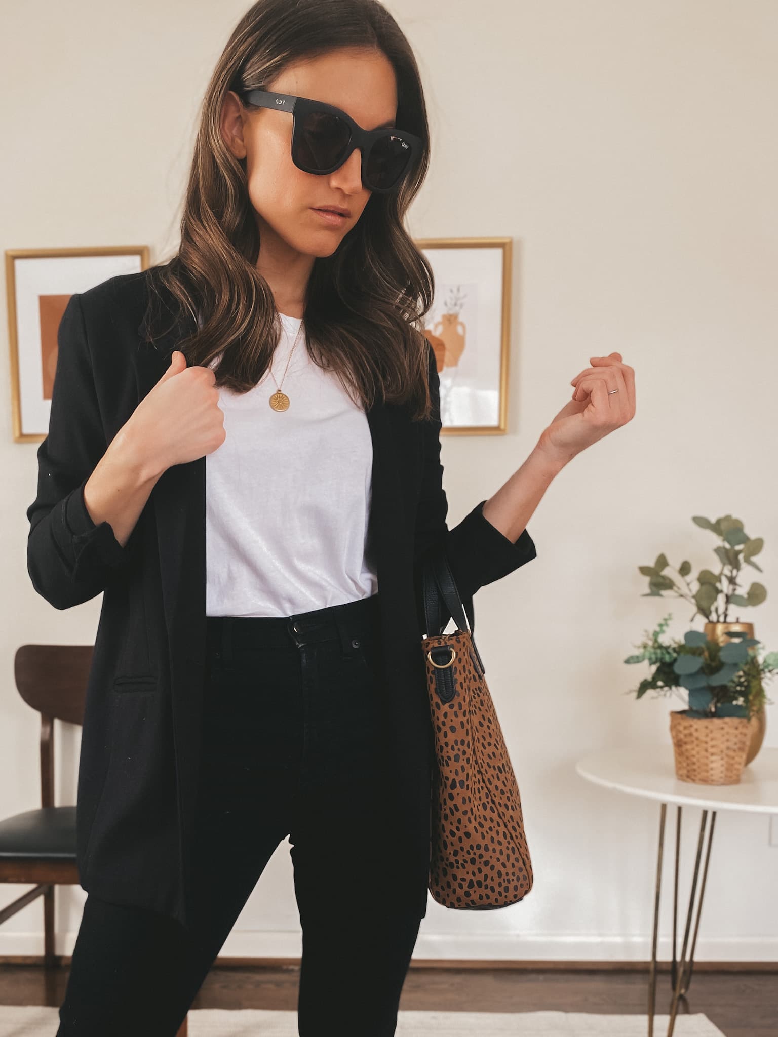 ashley wearing an Everlane basic white tee, a black Old Navy Blazer, Everlane black skinny jeans, square frame Quay sunglasses, holding a Target leopard tote bag