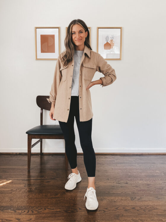 ashley wearing a gray tee, tan shacket, black leggings and white wool runners