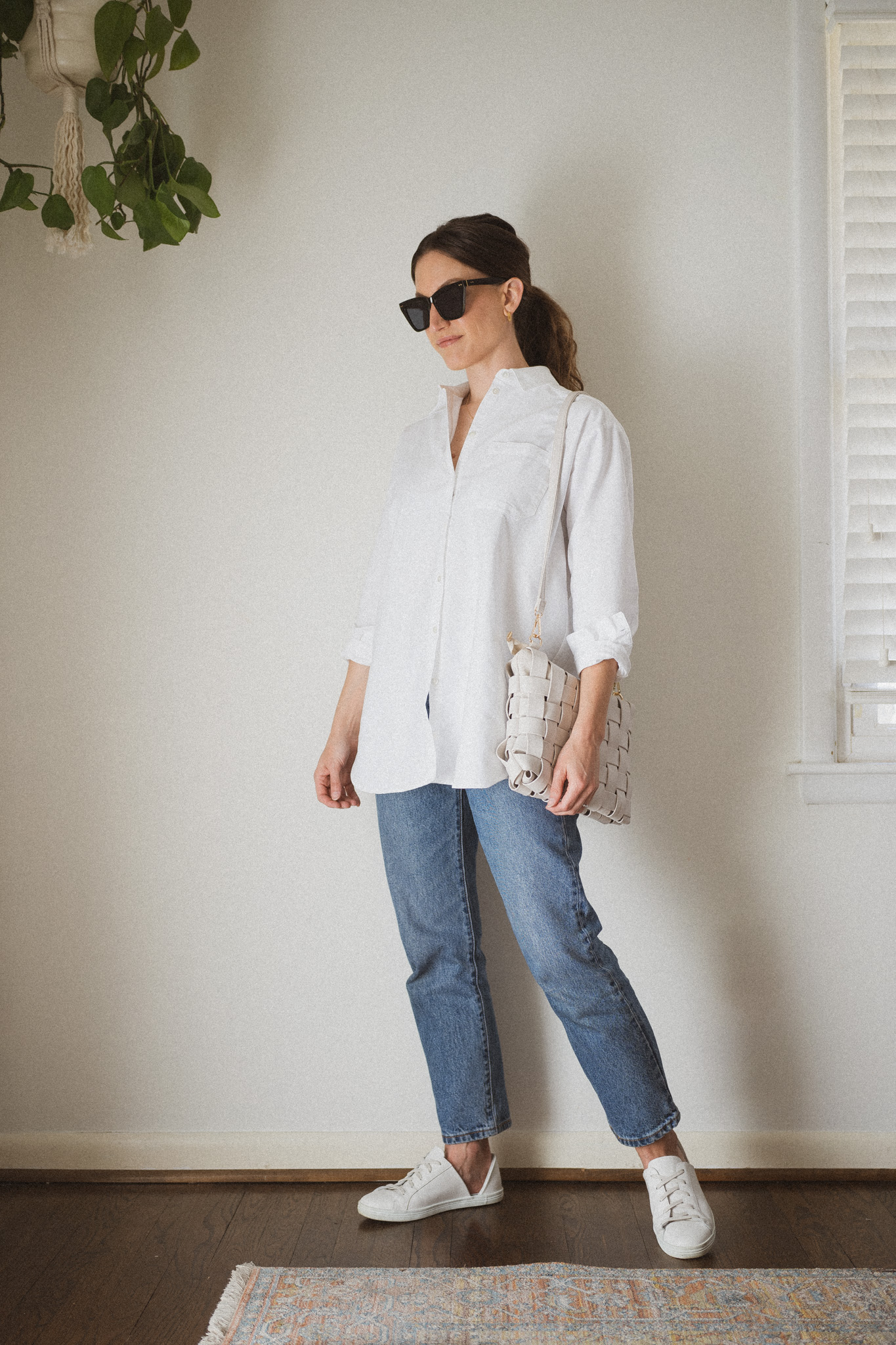 With white loose button down shirt, clutch, wide leg trousers and