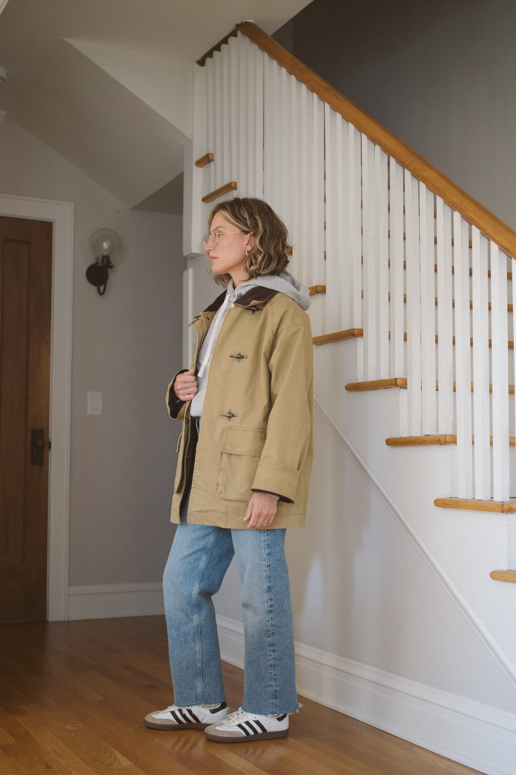 barn jacket outfit with a gray hoodie, light wash jeans, and Adidas Sambas