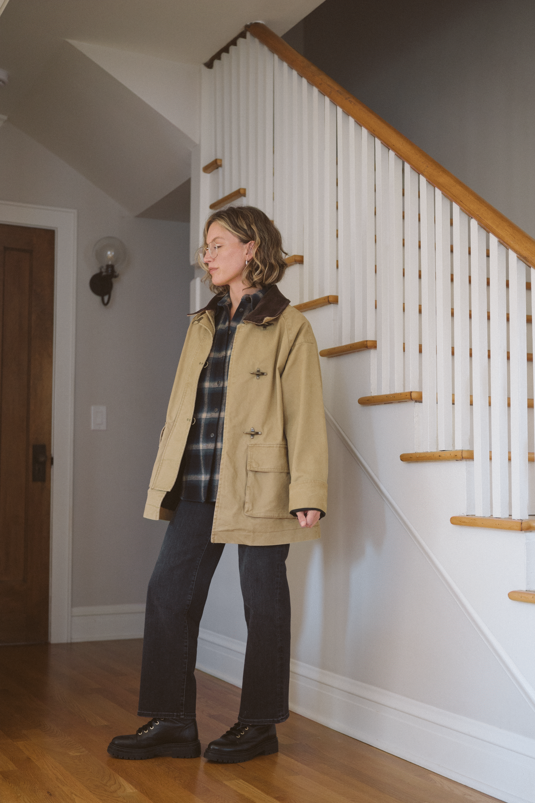 barn jacket outfit with a plaid shirt, black cropped denim, and lace up boots