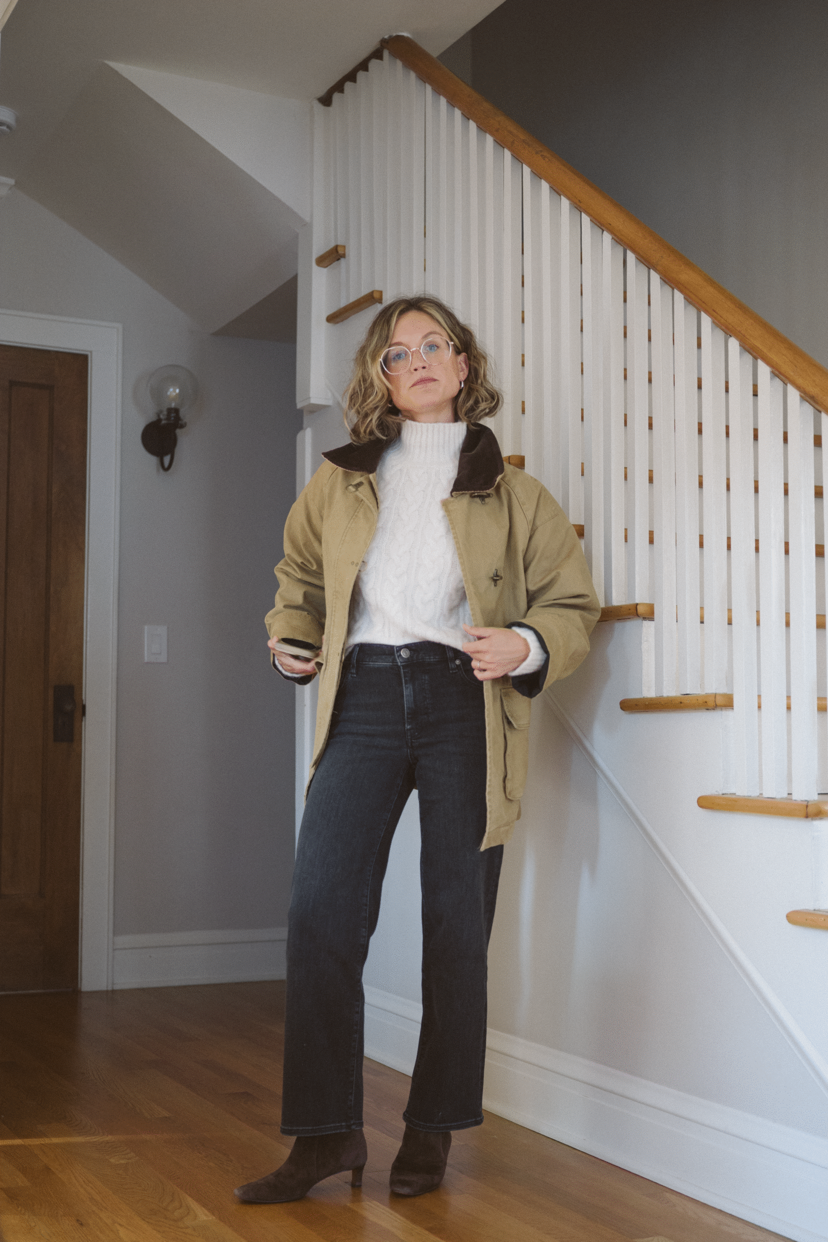 barn jacket outfit with a cable knit sweater, black cropped jeans, and brown ankle boots