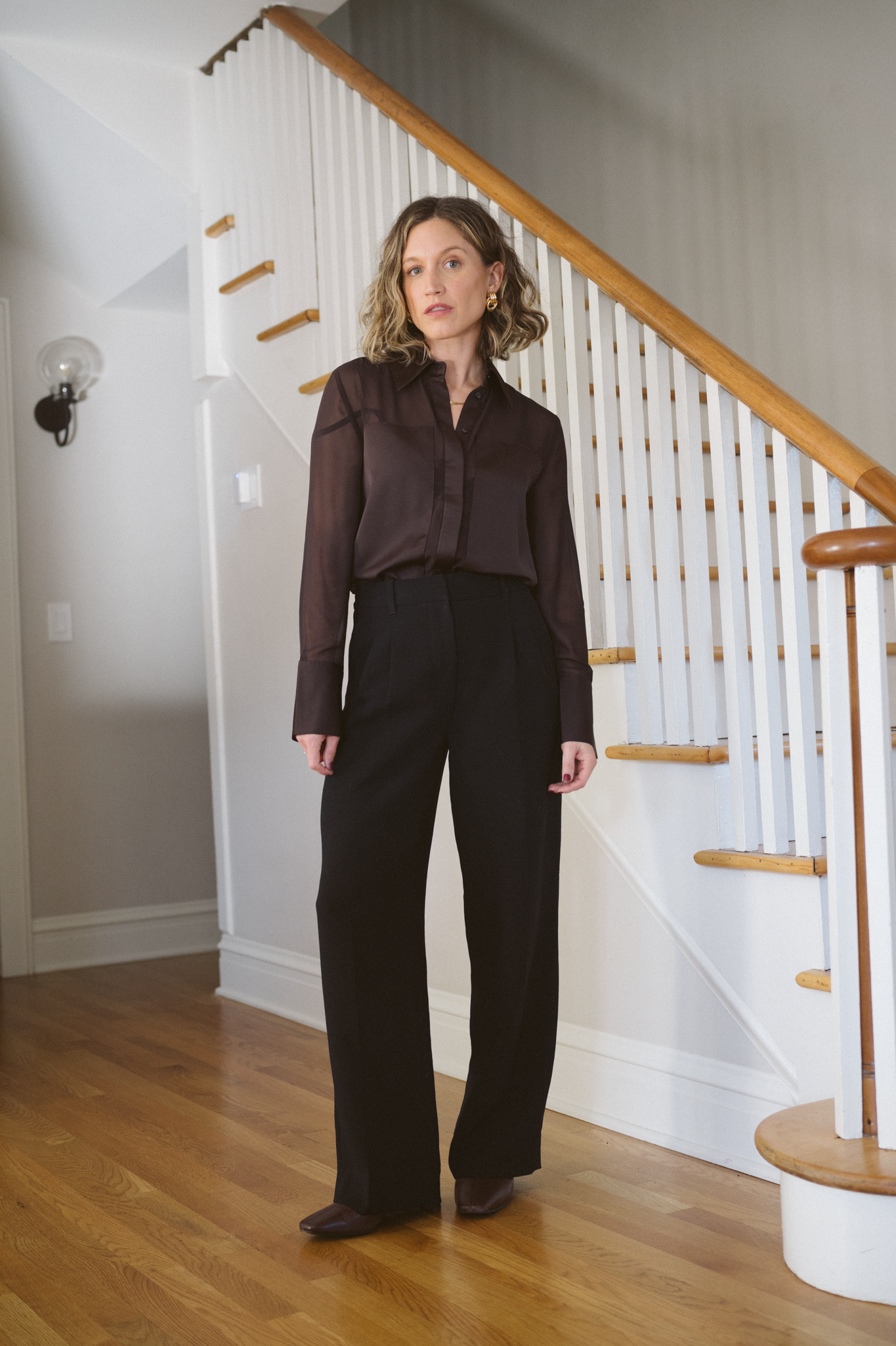 thanksgiving outfit with a brown blouse, black trousers, and brown heeled ankle boots